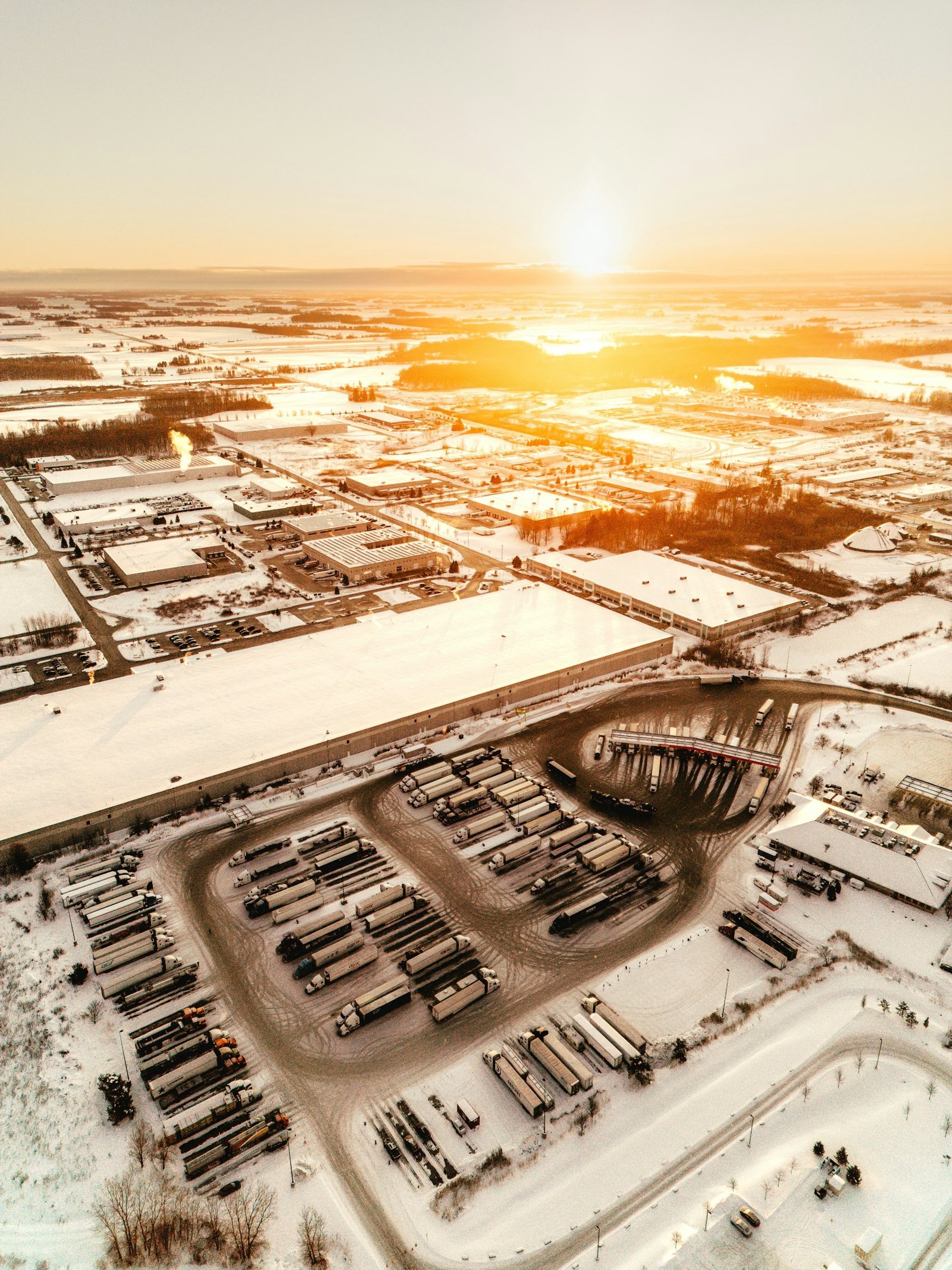 Sunrise over a snowy industrial park and truck yard